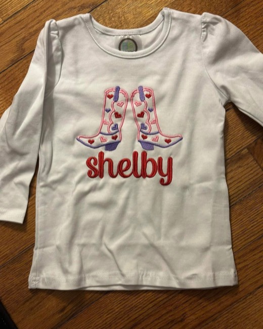 Cowgirl boots and a first name stitched on a girls top